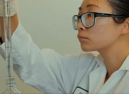 Lab Tech looking at vial in their hand